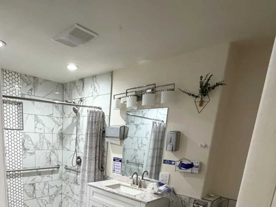 A second accessible bathroom with a step-free tiled shower and grab bars