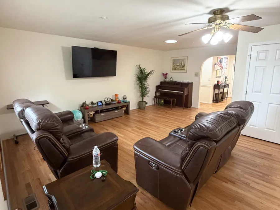 The second living room, with reclining armchairs, a television and an upright piano